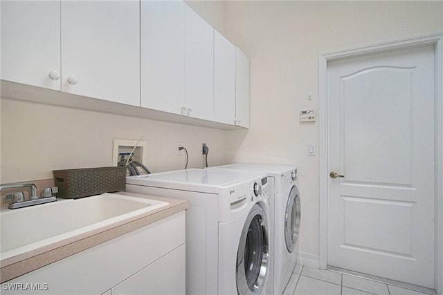 washroom featuring cabinets, independent washer and dryer, sink, and light tile patterned floors