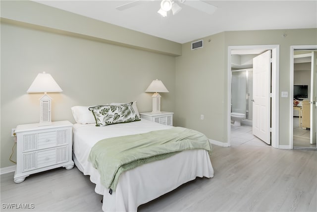 bedroom with ceiling fan, ensuite bathroom, and light wood-type flooring