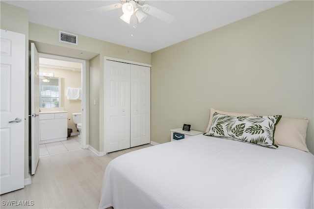 bedroom featuring ceiling fan, a closet, connected bathroom, and light hardwood / wood-style flooring