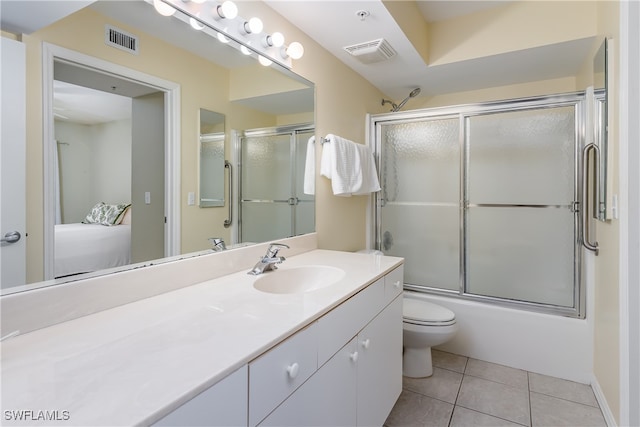 full bathroom featuring tile patterned floors, vanity, combined bath / shower with glass door, and toilet