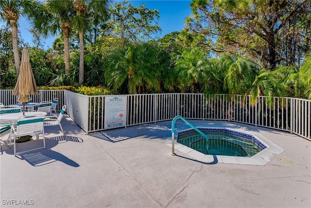 view of pool with a hot tub