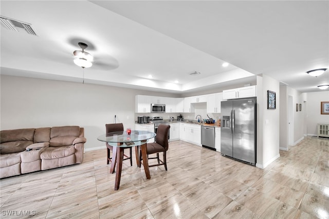 dining space with ceiling fan and sink