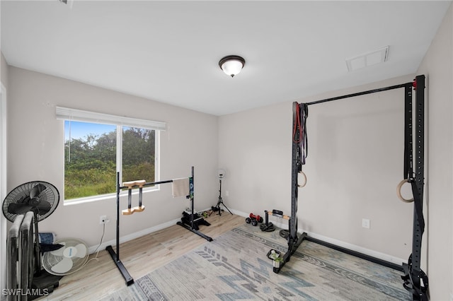 exercise room with light hardwood / wood-style floors