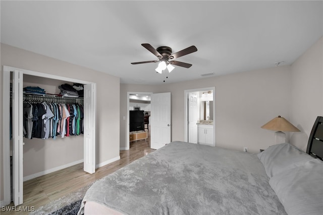 bedroom featuring ensuite bath, light hardwood / wood-style flooring, a closet, and ceiling fan