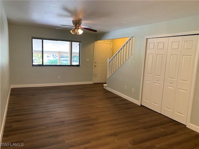 unfurnished living room with ceiling fan and dark wood-type flooring