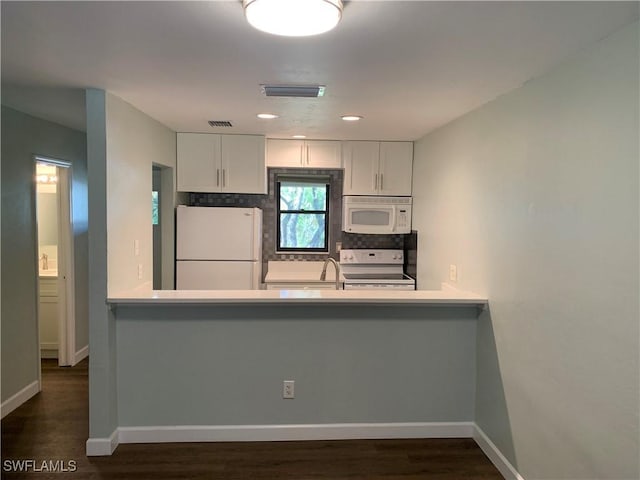 kitchen featuring white appliances, backsplash, white cabinets, sink, and dark hardwood / wood-style flooring