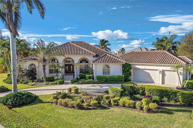 mediterranean / spanish-style home featuring a porch, a front yard, and a garage