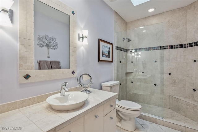 bathroom with toilet, a skylight, a walk in shower, and vanity