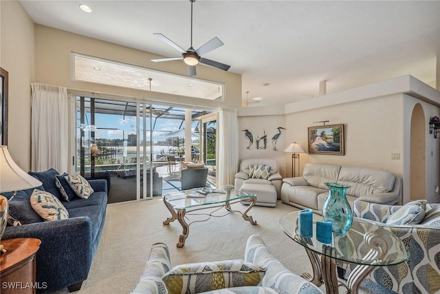 carpeted living area with a ceiling fan, arched walkways, and recessed lighting