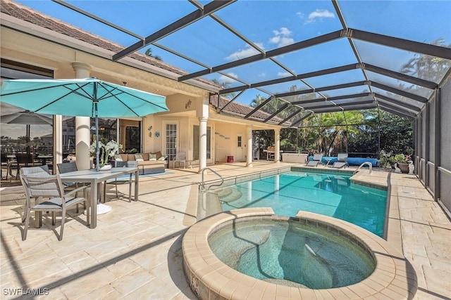 view of pool featuring a pool with connected hot tub, a lanai, and a patio