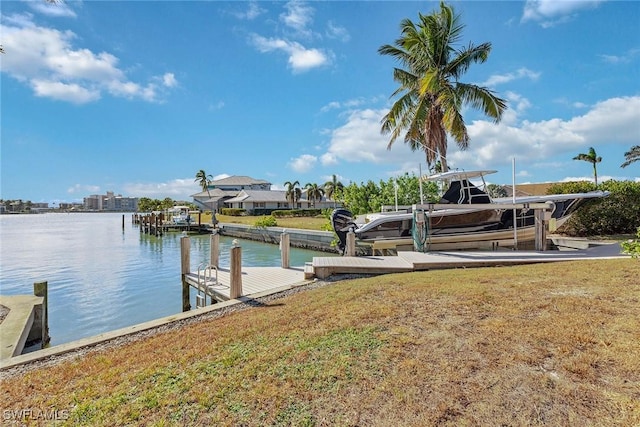 dock area with a water view, a yard, and boat lift