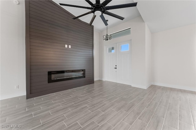 unfurnished living room featuring ceiling fan and a large fireplace