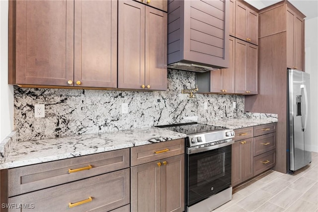 kitchen with stainless steel appliances, light stone countertops, and backsplash