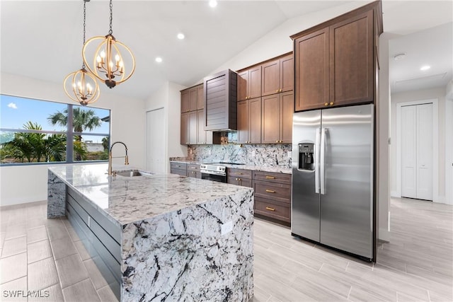 kitchen with sink, vaulted ceiling, hanging light fixtures, stainless steel appliances, and light stone countertops