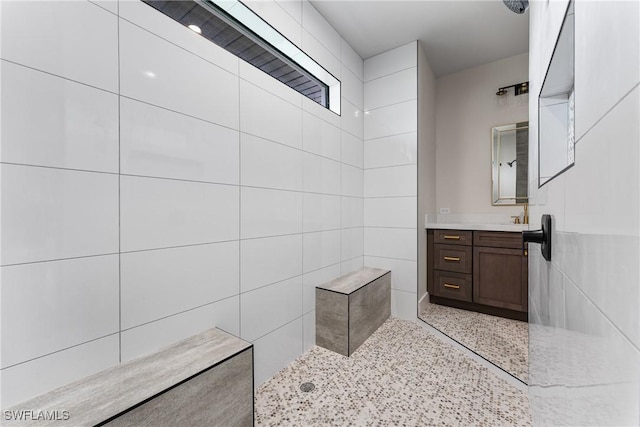 bathroom featuring walk in shower and vanity