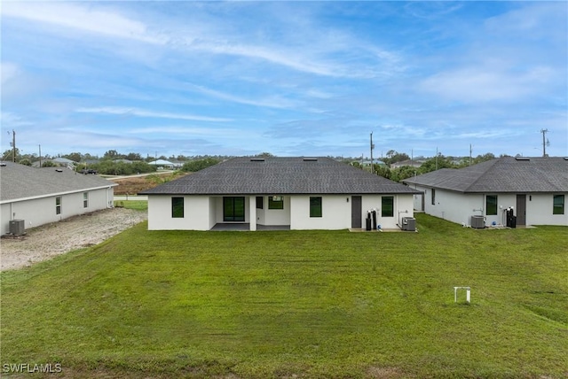 back of property with cooling unit and a lawn