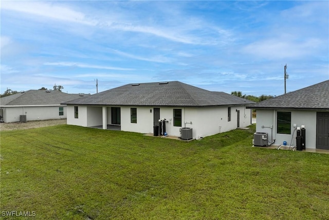 back of house with a yard and central AC