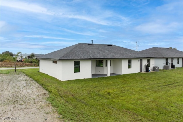 rear view of house with cooling unit and a yard