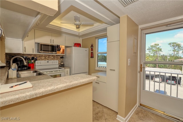 kitchen with white appliances, white cabinets, sink, ceiling fan, and light tile patterned floors