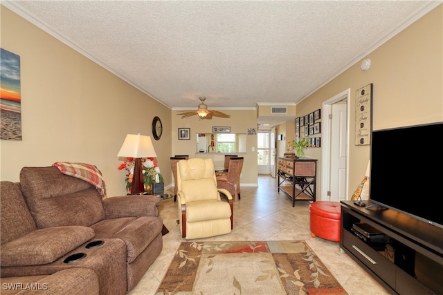 tiled living room with ceiling fan, ornamental molding, and a textured ceiling