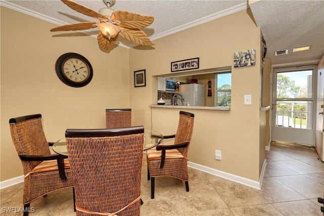 dining area featuring ceiling fan, crown molding, light tile patterned floors, and a textured ceiling