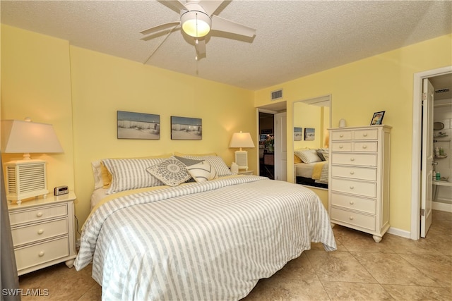 tiled bedroom featuring a textured ceiling and ceiling fan