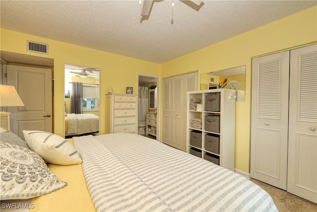 bedroom with two closets, ceiling fan, and a textured ceiling