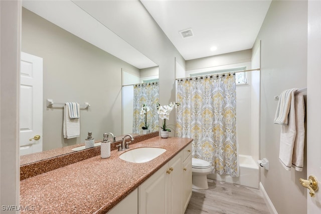 full bathroom with toilet, shower / tub combo, wood finished floors, visible vents, and vanity