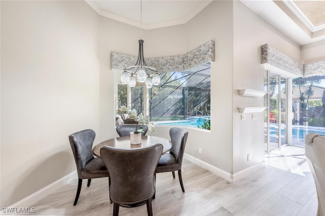 dining area with ornamental molding, a chandelier, baseboards, and wood finished floors