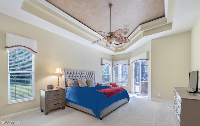 bedroom featuring light carpet, access to outside, baseboards, and a raised ceiling