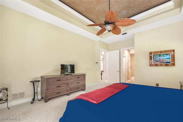 bedroom with light carpet, baseboards, visible vents, and a raised ceiling