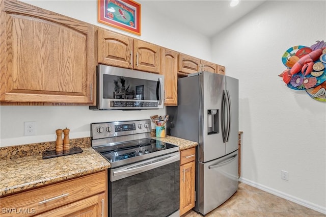 kitchen featuring baseboards, appliances with stainless steel finishes, and light stone countertops