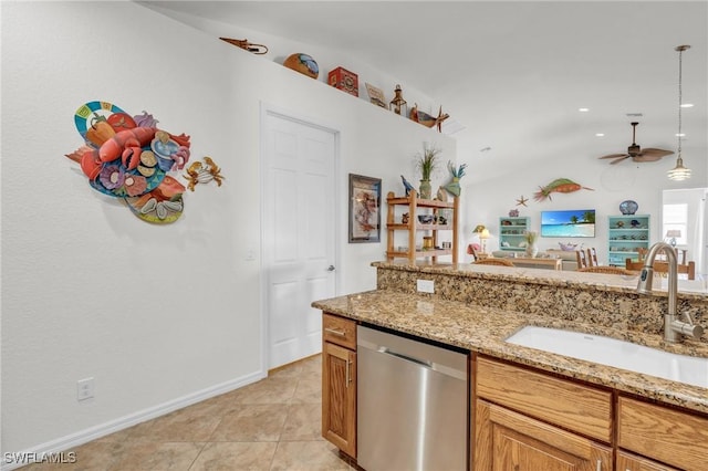 kitchen featuring hanging light fixtures, light stone countertops, stainless steel dishwasher, a sink, and light tile patterned flooring