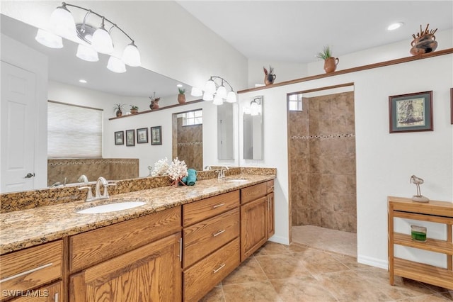 bathroom with a walk in shower, double vanity, and a sink