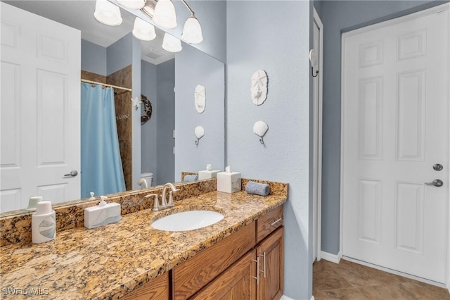 bathroom with curtained shower, tile patterned flooring, vanity, and baseboards