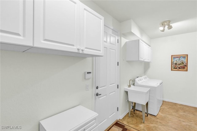 laundry room featuring cabinet space, baseboards, a sink, and independent washer and dryer