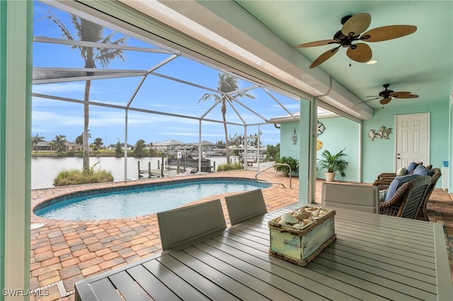 view of swimming pool featuring glass enclosure, a dock, a water view, ceiling fan, and a patio