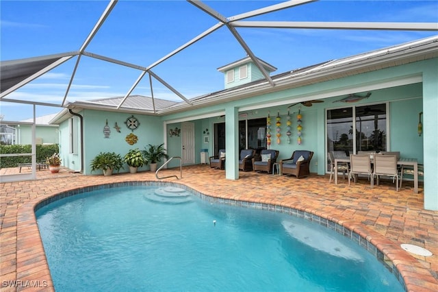 outdoor pool featuring a patio area, ceiling fan, glass enclosure, and an outdoor living space