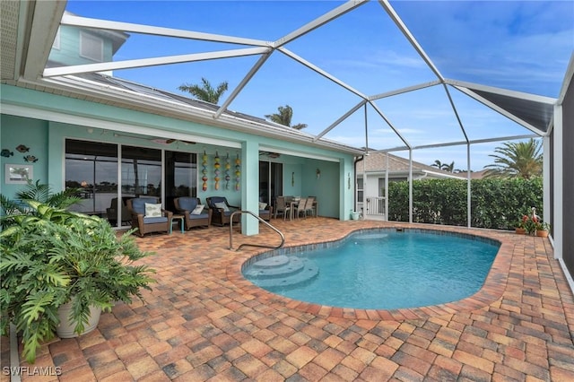 outdoor pool featuring a ceiling fan, glass enclosure, a patio, and an outdoor living space