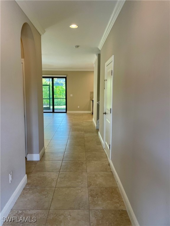 hall with light tile patterned flooring and ornamental molding