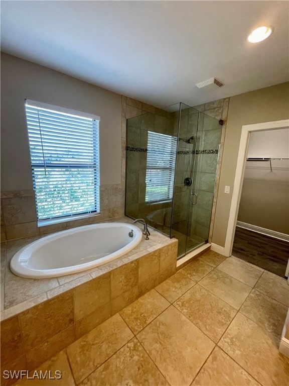 bathroom with tile patterned flooring and separate shower and tub