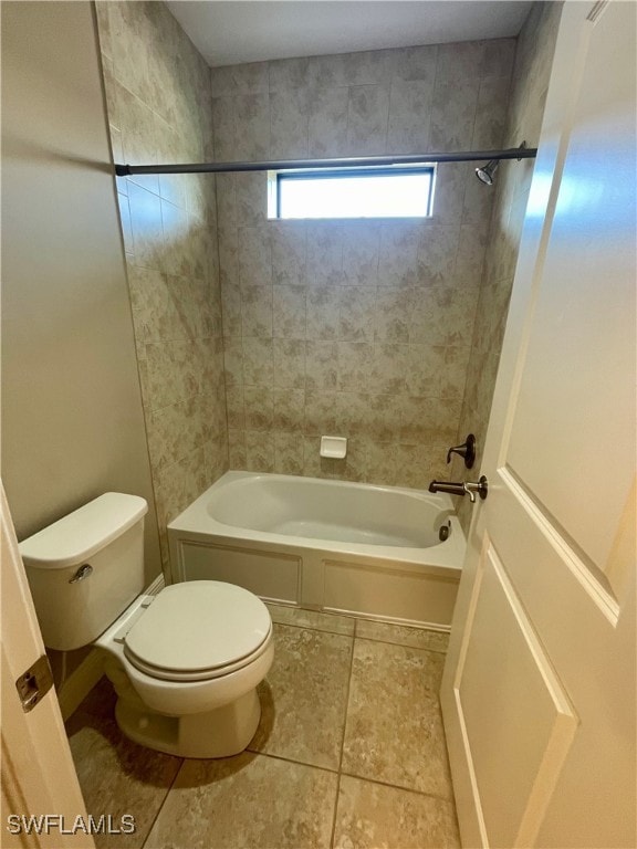 bathroom featuring tile patterned floors, toilet, and tiled shower / bath