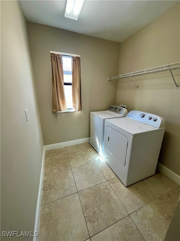 laundry room with washer and dryer and light tile patterned floors