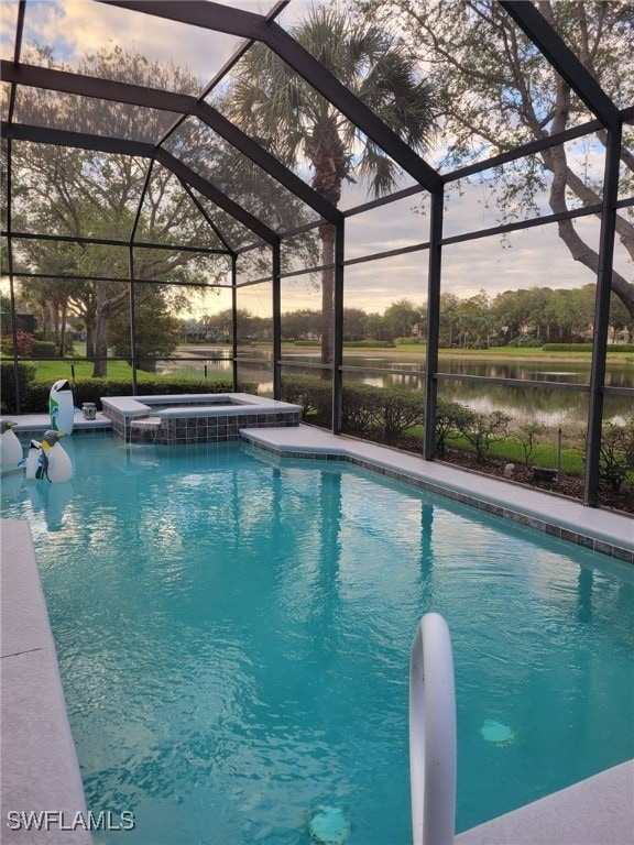 pool at dusk with an in ground hot tub, a water view, and a lanai