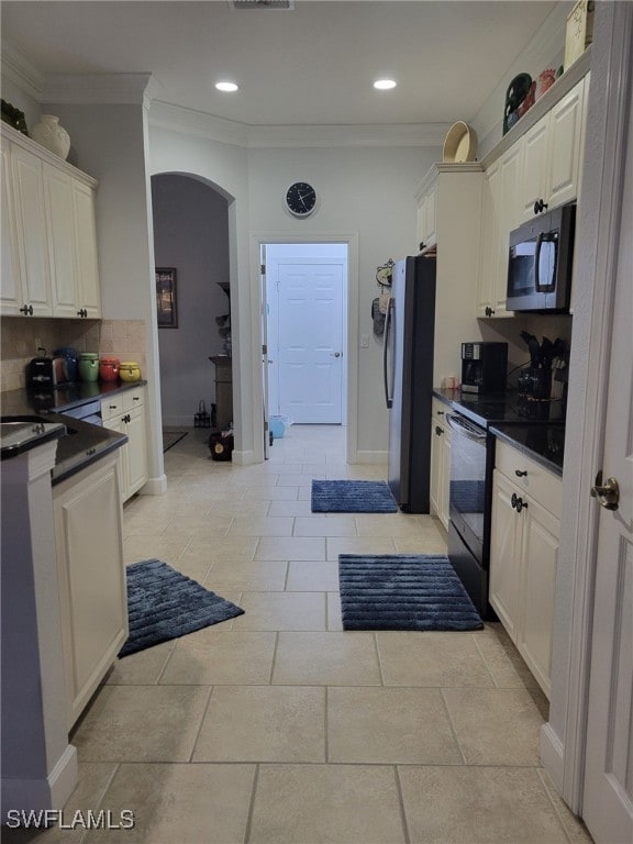 kitchen featuring electric range, white cabinetry, stainless steel refrigerator, and ornamental molding