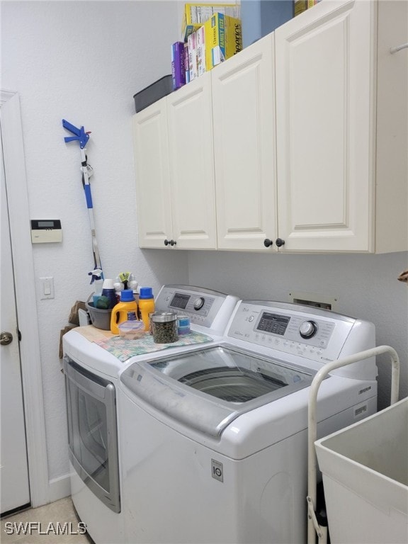 laundry area with washer and dryer, light tile patterned floors, cabinets, and sink