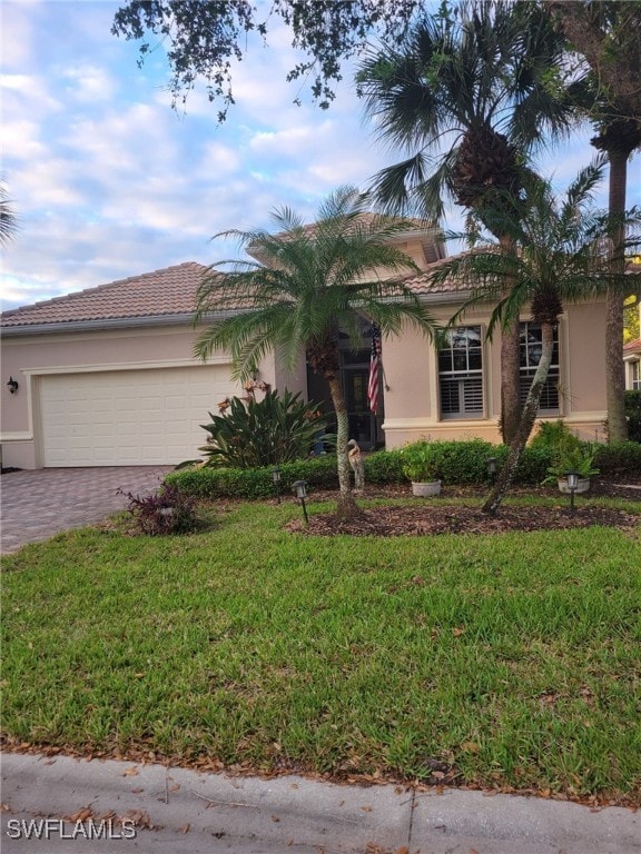 view of front of property featuring a front lawn and a garage