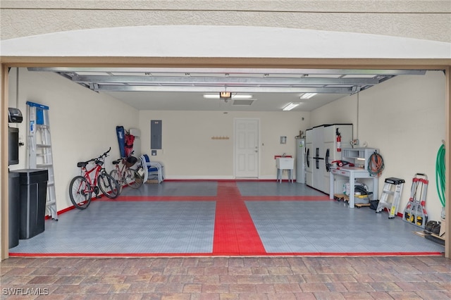 garage featuring electric panel and water heater