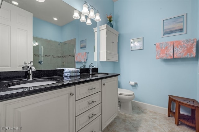 bathroom with tile patterned flooring, vanity, toilet, and tiled shower