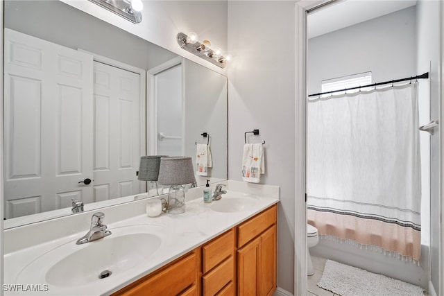 full bath with shower / tub combo, a sink, toilet, and double vanity